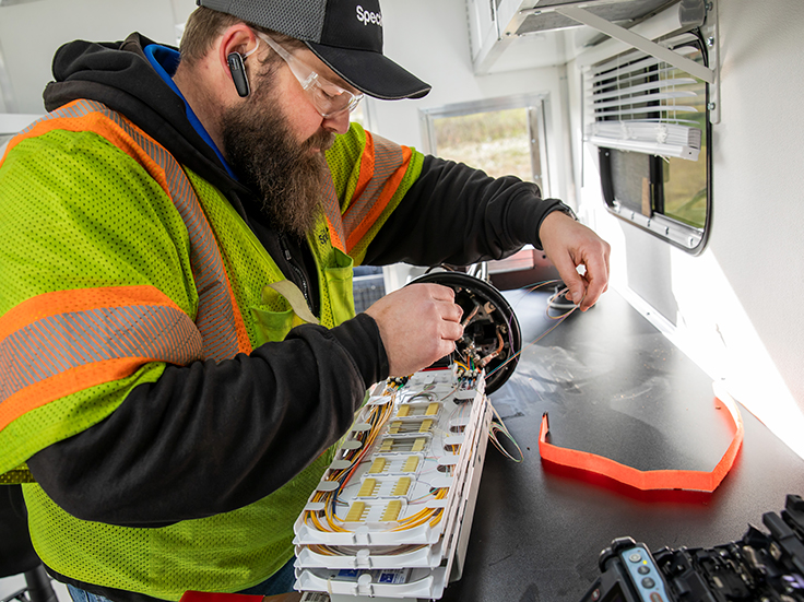 Charter technician splicing fiber for broadband deployment