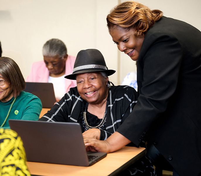 Woman in hat getting training in a computer lab