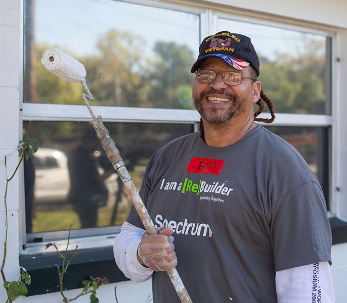 Spectrum Community Center Assist volunteer painting with a roller